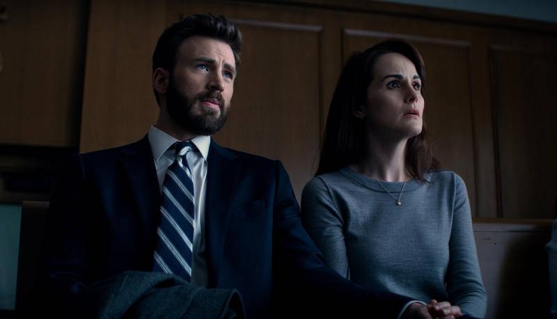 This image released by Apple TV Plus shows Chris Evans, left, and Michelle Dockery in a scene from "Defending Jacob." The six-part Apple TV Plus drama series, adapted from the 2012 New York Times best-selling novel by William Landay, premieres April 24. (Apple TV Plus via AP)
