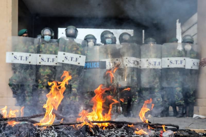 A pyre lit by members and supporters of Sri Lanka's opposition party alliance, the Samagi Jana Balawegaya (United People's Power) burns out as police guard the entrance to the Presidential Secretariat at Galle Face in Colombo, Sri Lanka, March 15, 2022. EPA