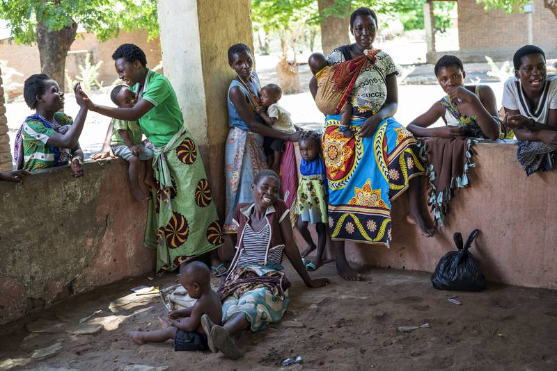 Parents wait for their young children to receive the Mosquirix vaccine. AP 