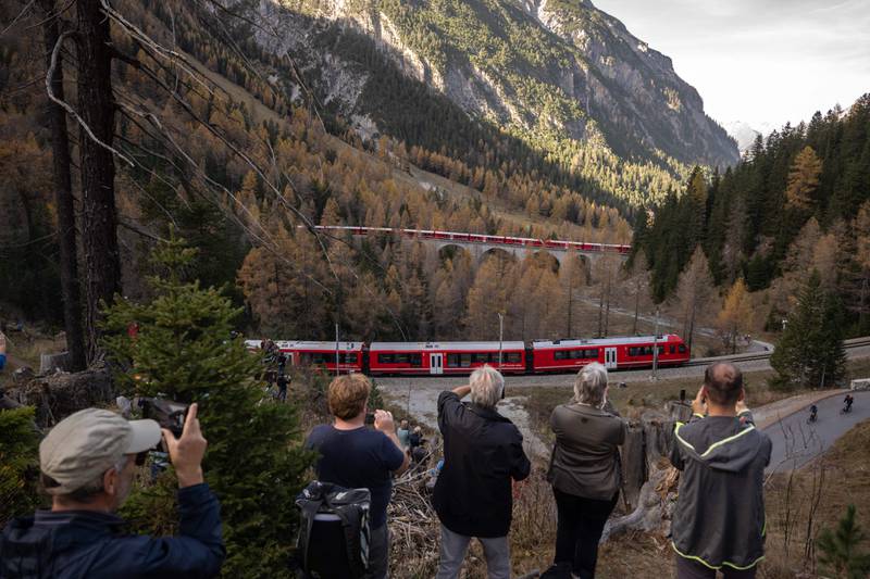 People record a 1,910-metre-long train with 100 cars near Bergun, Switzerland during a successful record attempt by the Rhaetian Railway to run the world's longest passenger train. All photos by AFP