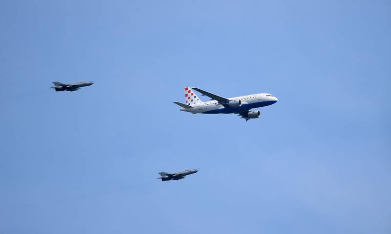 The Airbus 319 airplane carrying the Croatian national football team, is escorted by two military aircrafts upon arrival to the international airport in Zagreb on Monday. Attila Kisbenedek / AFP