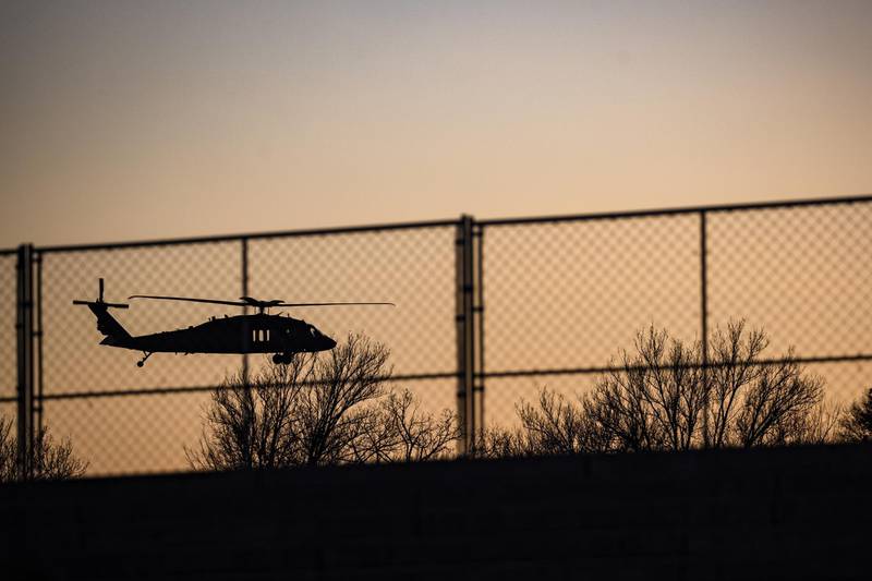 A Blackhawk helicopter flies behind a recently constructed security fence on the National Mall in Washington, DC, US, on Tuesday, January 12, 2021. Bloomberg