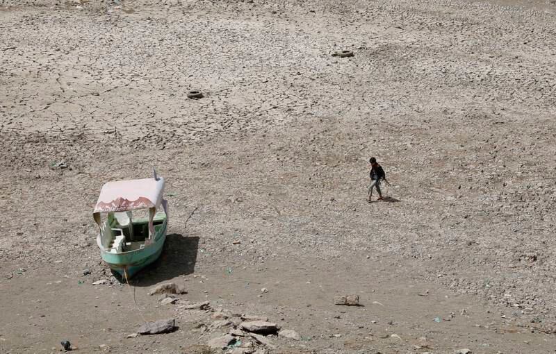 A man walks past an abandoned boat in the bed of a drought-affected reservoir on the outskirts of Sana'a, Yemen. EPA