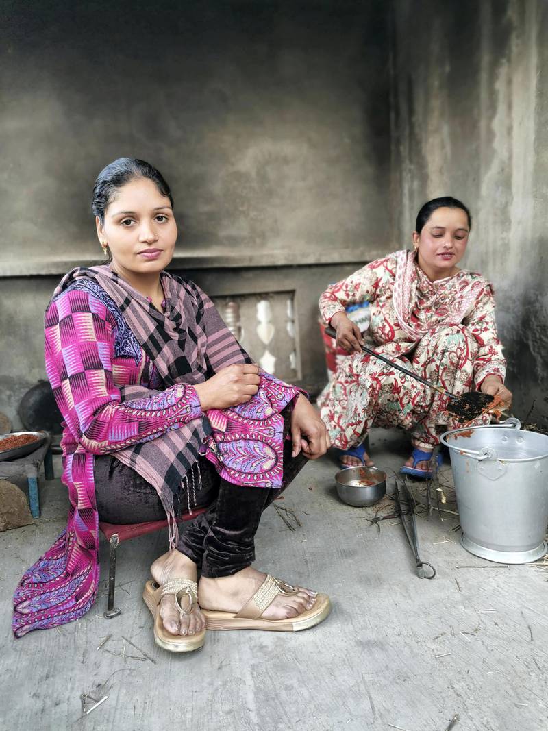 Amandeep Kaur, 38, and neighbour Harvinder Kaur, 33, cooking on clay stove. Amandeep Kaur’s husband Narpinder Singh has been protesting against the farm laws since November 26. Taniya Dutta for The National
