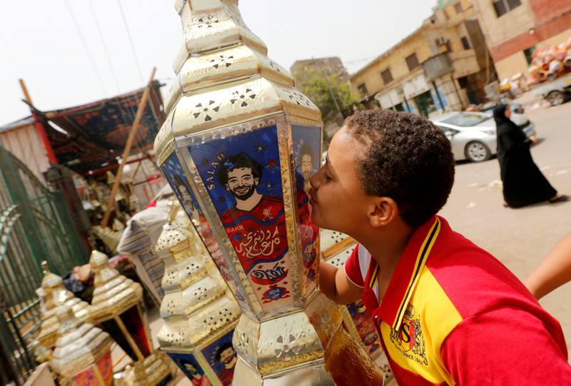 REFILE - ADDING RESTRICTIONS An Egyptian boy kisses the traditional decorative lanterns known as "Fanous" bearing the image of Liverpool's Egyptian forward soccer player Mohamed Salah, at a market, before the beginning of the holy fasting month of Ramadan in Cairo, Egypt May 2, 2018. Arabic words read "Ramadan is sweeter with Salah". REUTERS/Amr Abdallah Dalsh  NO RESALES. NO ARCHIVES.