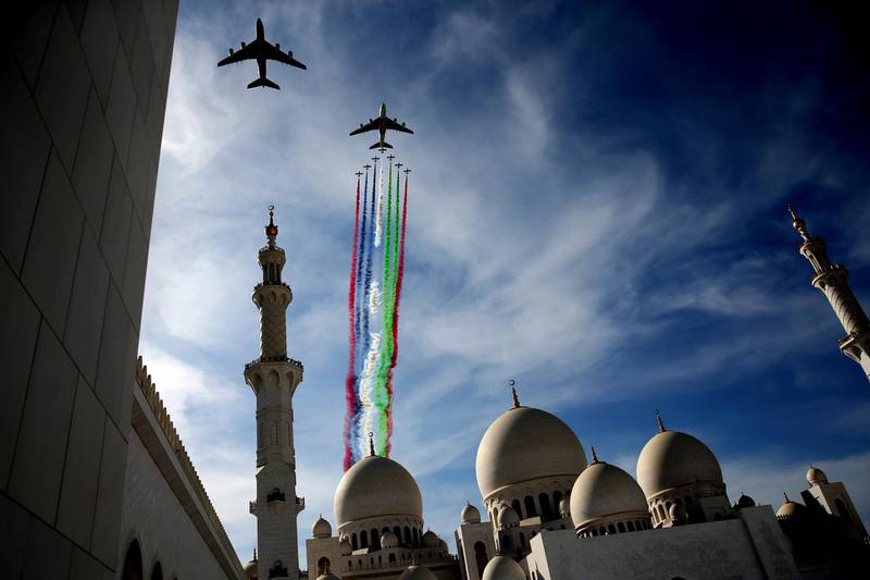 Two Etihad and Emirates planes, followed by the Al Fursan aerobatic team, perform a display show over the Sheikh Zayed Grand Mosque to celebrate the UAE's 47th National Day and the Year of Zayed, in Abu Dhabi, United Arab Emirates, Sunday, Dec. 2, 2018. (AP Photo/Kamran Jebreili)