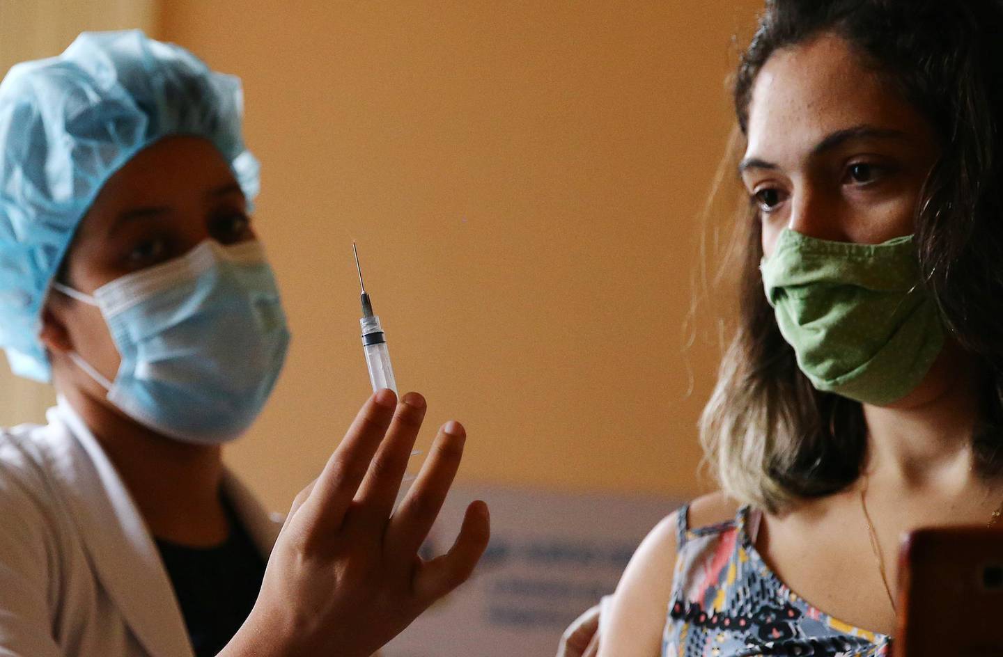 RIO DE JANEIRO, BRAZIL - MAY 24: Nurse-in-training Julia Ramos displays the empty syringe after vaccinating a person at a COVID-19 vaccination clinic at Museu da Republica (Museum of the Republic) on May 24, 2021 in Rio de Janeiro, Brazil. COVID-19 has claimed more than 1 million lives in Latin America and the Caribbean, with nearly half of those deaths in Brazil. Only three percent of the population of Latin America has been fully vaccinated against COVID-19. Health experts are warning that Brazil should brace for a new surge of COVID-19 amid a slow vaccine rollout and relaxed restrictions. Nearly 450,000 people have died in Brazil by COVID-19, second only to the U.S. (Photo by Mario Tama/Getty Images)