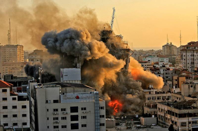 Smoke and flames rise from Al Sharouk tower, as it collapses after being hit by an Israeli air strike in Gaza City. AFP