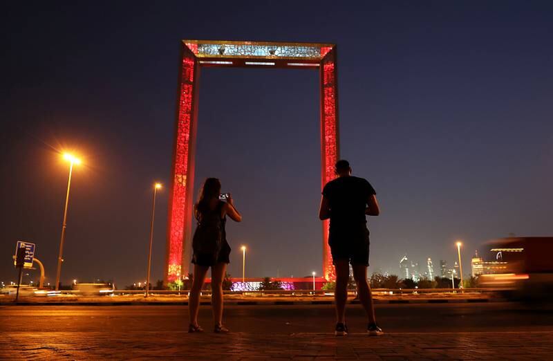 DUBAI , UNITED ARAB EMIRATES , JULY 19 – 2018 :-  Tourist taking photo of the Dubai Frame which lit up in red for the Chinese President Xi Jinping’s visit and UAE – China week at the Zabeel Park in Dubai.  ( Pawan Singh / The National )  For News Standalone/ Big Picture