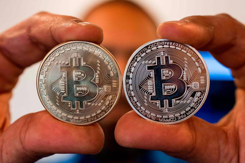 A picture taken on February 6, 2018 shows a person holding a visual representation of the digital crypto-currency Bitcoin, at the "Bitcoin Change" shop in the Israeli city of Tel Aviv. / AFP PHOTO / JACK GUEZ