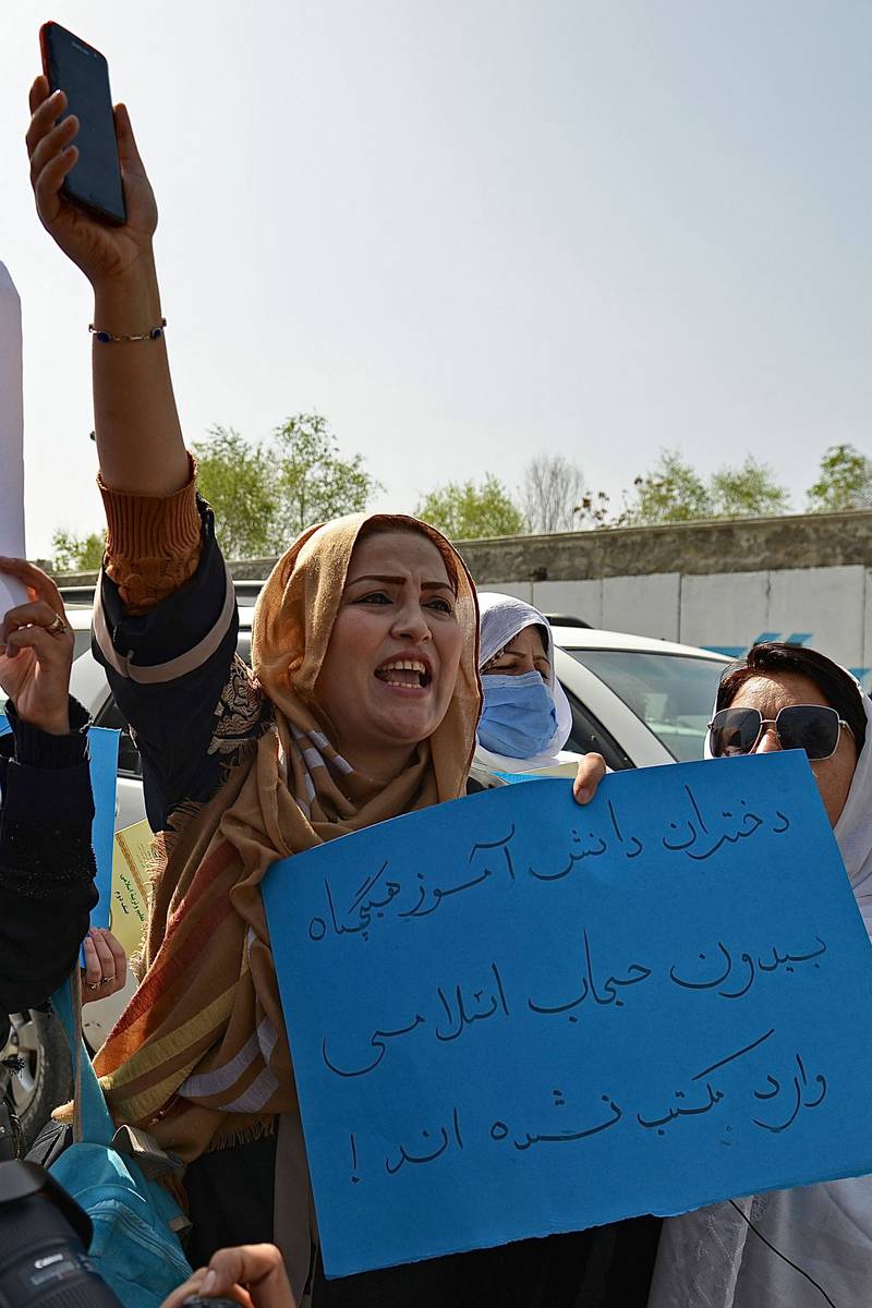 An Afghan woman takes part in a protest in front of the Ministry of Education in Kabul, demanding that high schools be reopened for girls. The ministry had posted a video online congratulating 'all pupils' on the beginning of the new term.