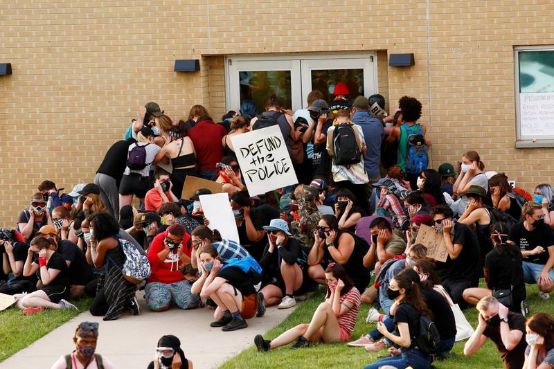 Protesters blocking an exit to the precinct of the officers who arrested Elijah McClain, cover their ears anticipating the use of flash-bang grenades by police in Aurora, Colorado, on July 3, 2020. Reuters