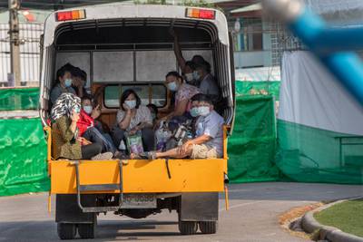 Migrant workers and their families ride in the back of a truck as they wait to be admitted to a field hospital for Covid-19 patients in Samut Sakhon, South of Bangkok, Thailand. AP Photo
