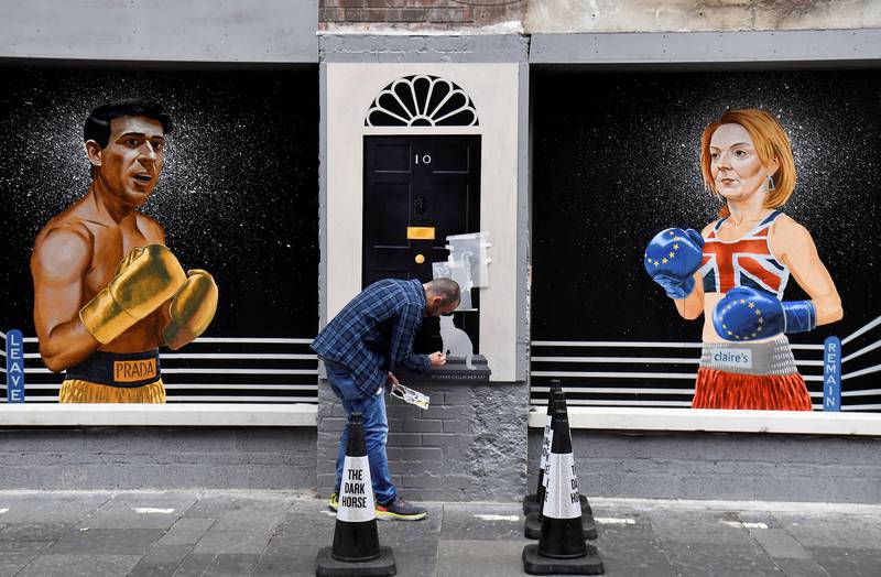 Artist Ciaran Gallagher finishes his mural depicting Britain's Conservative leadership candidates Rishi Sunak and Liz Truss, in Belfast, Northern Ireland. Reuters