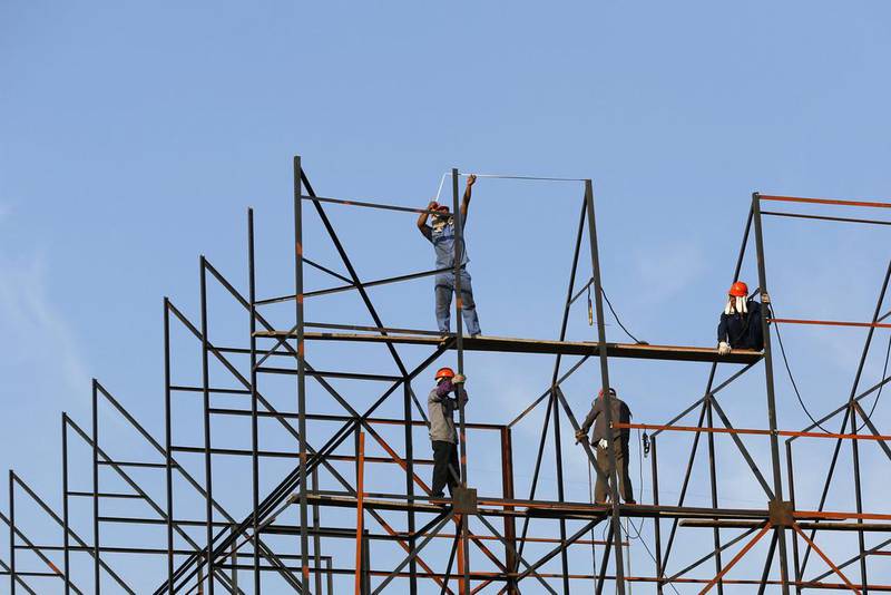 Labourers work on scaffolding at a construction site in Shanghai. China’s economy grew slightly faster than expected in the second quarter as a burst of government stimulus paid dividends. Aly Song / Reuters
