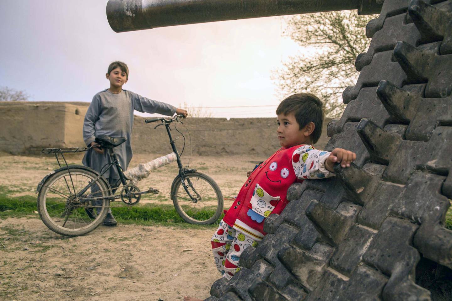 In Kandahar, where playgrounds are largely unavailable, children play on an old Soviet tank. Conflict is all-present in the southern province and eighteen years of American invasion haven't defeated the Taliban. Photo by Stefanie Glinski