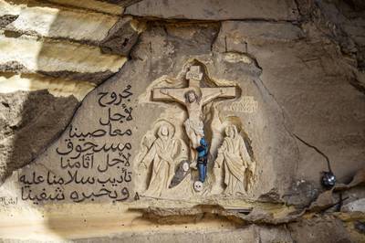Polish artist Mario, sculptor of St. Simon the Tanner Monastery complex, works on a scene relief depicting the Crucifixion of Jesus Christ and a verse in Arabic from the Biblical Book of Isaiah reading "he was wounded for our transgressions, he was bruised for our iniquities, the chastisement of our peace was upon him; and with his stripes we are healed", at the church in the Egyptian capital Cairo's eastern hillside Mokattam district. Mario spent more than two decades carving the rugged insides of the seven cave churches and chapels of the rock-hewn St. Simon Monastery and church complex atop Cairo's Mokattam hills, with designs inspired by biblical stories. It was all done to fulfil the wishes of the church's parish priest who met Mario in the early 1990s in Cairo. The Polish artist, who had arrived in Egypt earlier on an educational mission, was then looking for an opportunity to serve God at the monastery. AFP