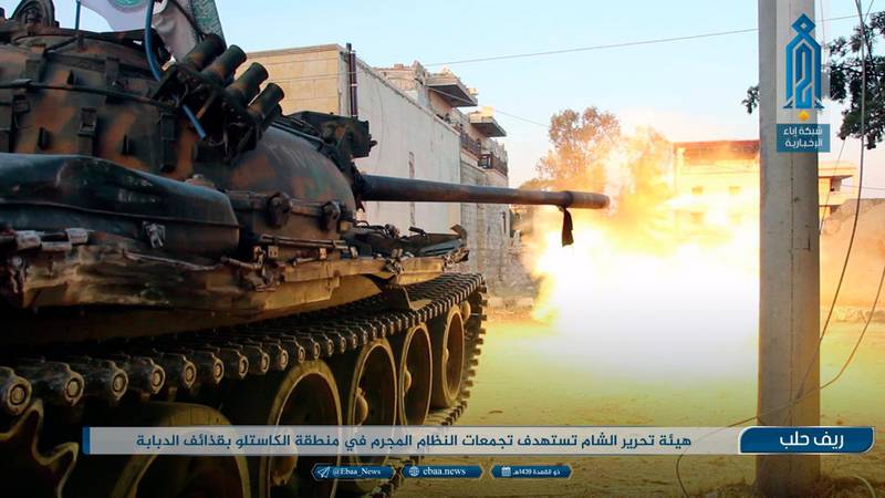 This photo provided on Monday, Aug 2, 2018, by the al-Qaida-affiliated Ibaa News Network, shows a tank of the al-Qaida-linked coalition known as Hay'at Tahrir al-Sham, Hay'at Tahrir al-Sham, Arabic for Levant Liberation Committee, firing at Syrian troops and pro-government gunmen in rural Aleppo, Syria. It's already being called the "mother of all battles," the last showdown between the forces of Syrian President Bashar Assad and the opposition. Idlib province, in Syria's northwest, is the only significant opposition enclave still standing and Assad has vowed to retake it. The caption in Arabic reads: "Hay'at Tahrir al-Sham targets groups of the criminal government faces in Castello area with tank shells." (Ibaa News Network, via AP)