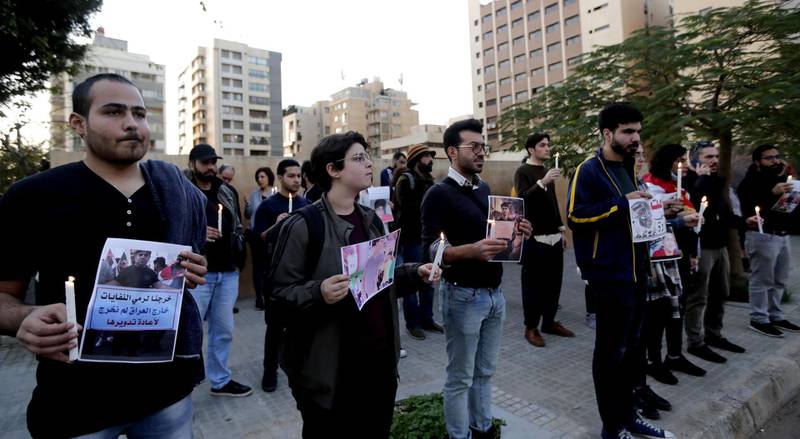 Lebanese demonstrators carry pictures of Iraqis killed during protests as they stage a candlelight vigil outside Iraq's embassy to denounce the excessive use of force against demonstrators there, in the capital Beirut. AFP