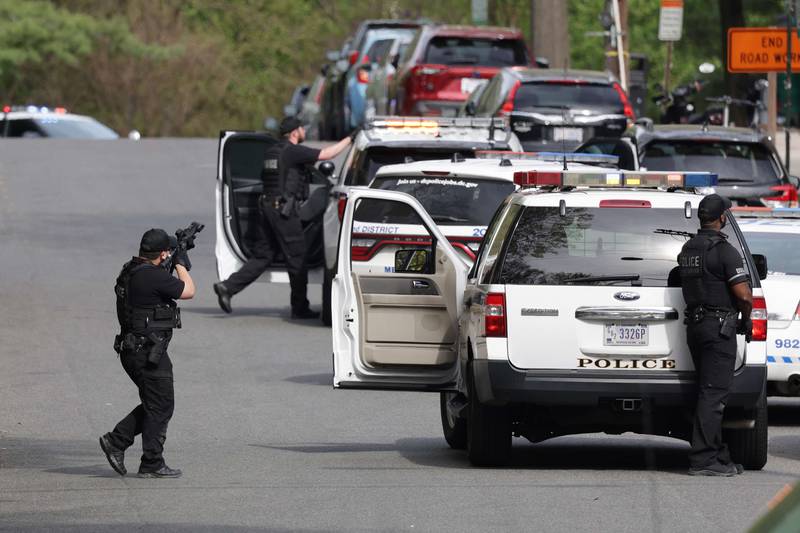 Police point their weapons at a building near the scene of the shooting. AFP