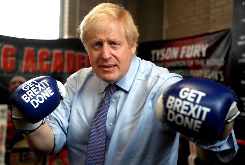 (FILES) In this file photo taken on November 19, 2019 Britain's Prime Minister and leader of the Conservative Party, Boris Johnson wears boxing gloves emblazoned with "Get Brexit Done" as he poses for a photograph at Jimmy Egan's Boxing Academy in Manchester north-west England on November 19, 2019. Electoral success, Brexit, a global health crisis that left him near death, divorce, engagement and even a new baby. Boris Johnson has had an eventful 12 months in anyone's book. Johnson, 56, marks his first anniversary as Britain's prime minister on Friday, having had what one lawmaker described to the Guardian newspaper as a "hell of a year". But his toughest test could yet be to come, as the full impact of the coronavirus outbreak bites on the UK economy, which has been battered by three months of enforced shutdown. / AFP / POOL / Frank Augstein
