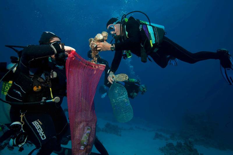 In this June 8, 2018 photo, divers collect plastic and other debris during a cleanup organized by Camel Dive Club, at a dive site off the coast of the Red Sea resort of Sharm el Sheik, in Southern Sinai, Egypt. An Egyptian official says his Red Sea province will impose a ban on disposable plastics, prohibiting everything from single use straws to plastic bags in an effort to fight plastic pollution. Ahmed Abdallah, governor of Hurghada province, said late on Tuesday, April, 2, 2019, that the ban will go into effect from June. (AP Photo/Thomas Hartwell,)