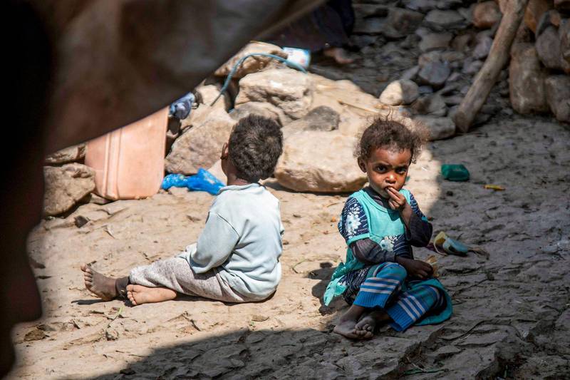 Children sit on the ground by a cave where a Yemeni family has sought refuge due to poverty and lack of housing, west of the suburbs of Yemen's third-city of Taez.   AFP