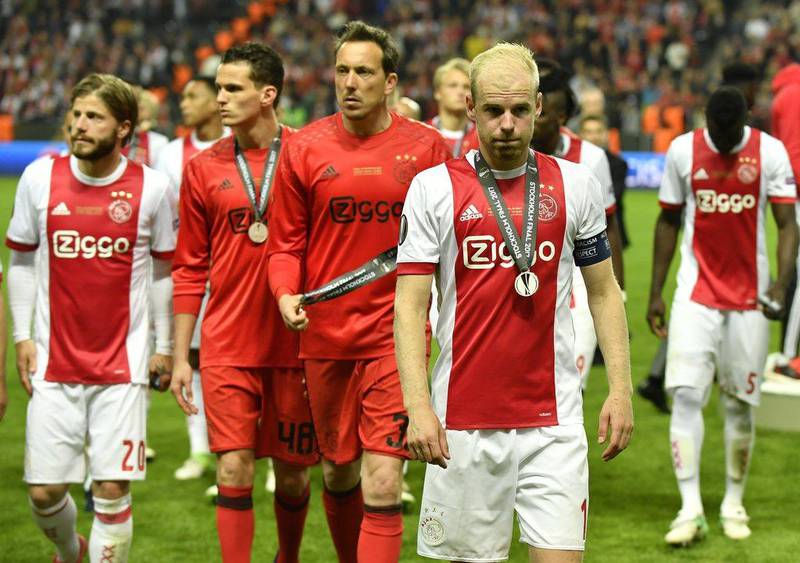 Ajax players leave the field after collecting their runner-up medals. Peter Powell / EPA