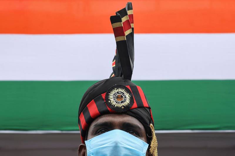 A police officer wearing a mask takes part in a full-dress rehearsal for India's Independence Day celebrations in Kolkata, India. Reuters