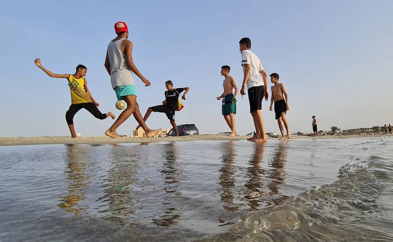 Libyan youths play football on the beach in the town of Garabulli, some 70 kms east of the capital Tripoli, on May 24, 2021. Oil-rich Libya has been torn by conflict since the toppling and killing of dictator Moamer Kadhafi in 2011. But in October 2020, rival groups signed a truce, setting in motion a UN-led process that saw a new transitional government installed.
 / AFP / Mahmud TURKIA
