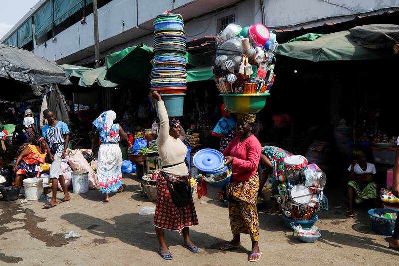 Market sellers carry their wares in the Adjame district of Abidjan, Ivory Coast. Reuters