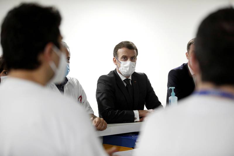 FILE PHOTO: French President Emmanuel Macron speaks with staff working in the Intensive Care Unit (ICU) during a visit at the Poissy/Saint-Germain-en-Laye hospital, near Paris, France, March 17, 2021. Yoan Valat/Pool via REUTERS/File Photo