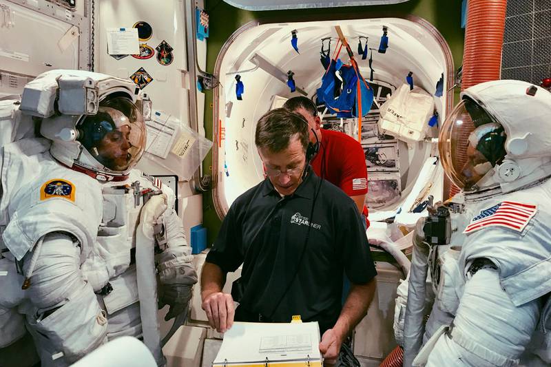In this February 2019 photo made available by NASA and Boeing, Boeing astronaut Chris Ferguson helps NASA astronauts Nicole Mann, left, and Mike Fincke, right, train for a spacewalk inside the International Space Station Airlock Mockup at NASA's Johnson Space Center in Houston. The three are assigned to Boeing's Crew Flight Test, Starliner's first flight with crew as part of NASA's Commercial Crew Program. The Starliner capsule, supposed to make its debut in April 2019, was pushed back until August. (NASA/Boeing via AP)