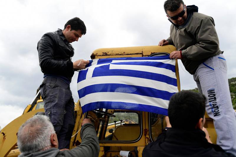 Local residents hang the Greek flag at a roadblock in Karava, on the northeastern Aegean island of Lesbos. AP