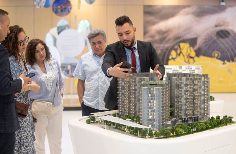 A sales agent shows prospective buyers some of the apartments on sale at Expo City. Ruel Pableo for The National