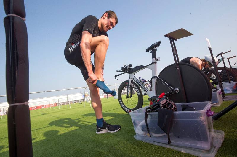 Dubai, United Arab Emirates - Participant changing his shoes for the run at the Ironman race at Jumeirah open beach, Dubai. Leslie Pableo for The National