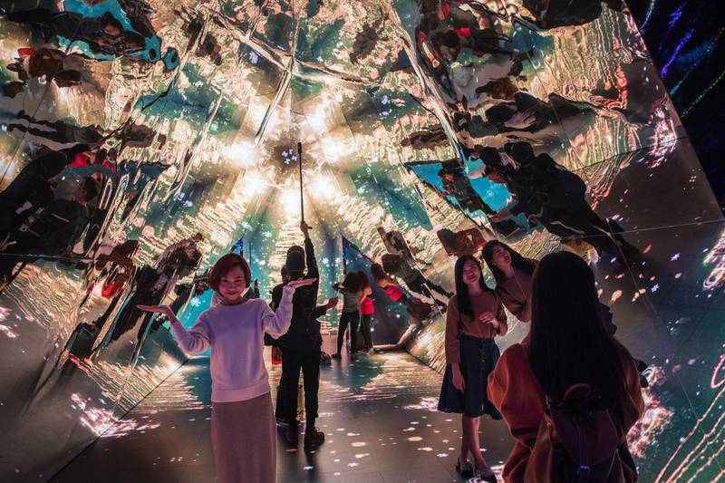 People pose for photographs inside a video kaleidoscope at Harbour City shopping mall, operated by Wharf Holdings Ltd., in Hong Kong, China. Bloomberg