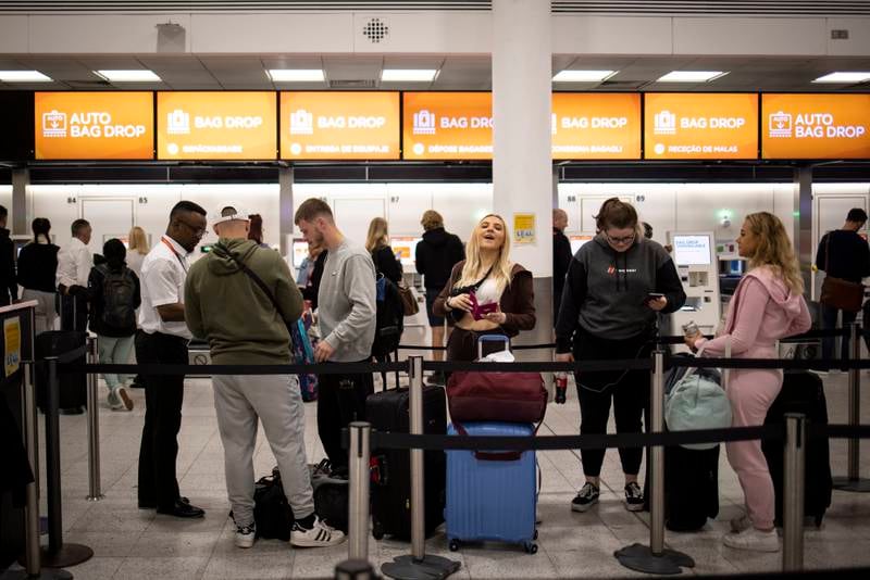Travellers queue to check in for their easyJet flights at Gatwick Airport. EPA