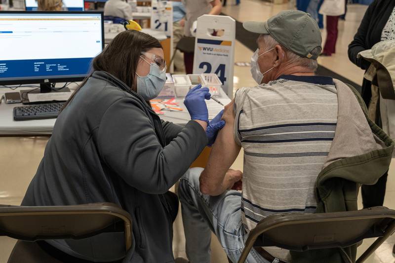 A healthcare worker injects a West Virginian with a dose of the Covid-19 vaccine. Willy Lowry / The National