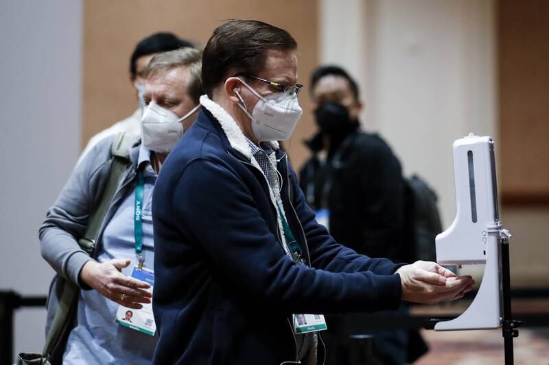 A member of the media disinfects his hands after a temperature check at CES 2022. Visitors must be fully vaccinated against Covid-19 to attend the event in person. EPA