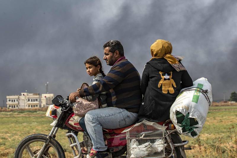 Members of a Syrian family use a motorcycle to flee Ras Al Ain to the countryside.  AFP