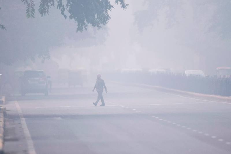 TOPSHOT - A man crosses a street in smoggy conditions in New Delhi on November 4, 2019. Millions of people in India's capital started the week on November 4 choking through "eye-burning" smog, with schools closed, cars taken off the road and construction halted. / AFP / Jewel SAMAD

