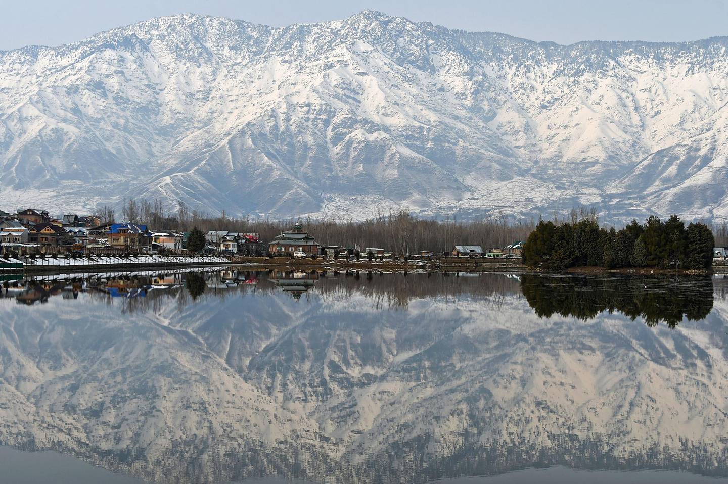 Kashmiri snow-covered mountains are reflected in Dal Lake in Srinagar on February 9, 2019. - Beause of recent heavy snowfalls, the roads in Kashmir linking with the rest of India and the Jammu-Srinagar national highway were cut off. (Photo by TAUSEEF MUSTAFA / AFP)