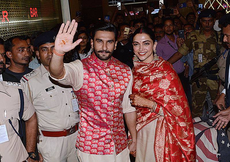 Bollywood actors and recently-wedded couple Ranveer Singh (L) and Deepika Padukone acknowledge fans gathered at the Mumbai international airport early on November 18, 2018, following their return from their nuptials at Italy's Lake Como.  Photo / AFP
