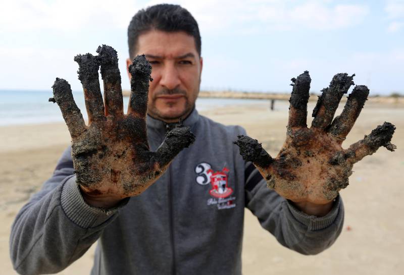 A man shows tar on his hands in the aftermath of an oil spill in the Mediterranean, in Tyre nature reserve, Lebanon. Reuters
