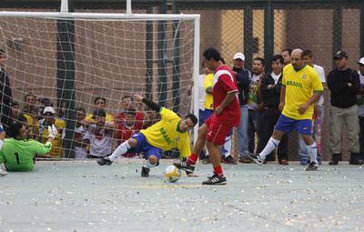 Prisoners, wearing jerseys in the colours of Brazil's national football team, play against a team of veteran Peruvian players, who are visitors to the Castro-Castro prison in Lima for the Prison World Cup event ahead of the 2014 World Cup in Brazil. Mariana Bazo / Reuters / June 2, 2014