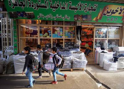 Iraqi boys walk past a shop in a local market in the northern city of Mosul on November 21, 2018.   / AFP / Zaid AL-OBEIDI
