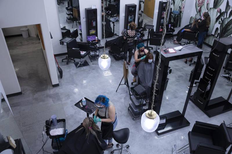 Stylists wear protective masks and gloves while working on customer's hair at a Belazza salon in Tucson, Arizona, US. Bloomberg