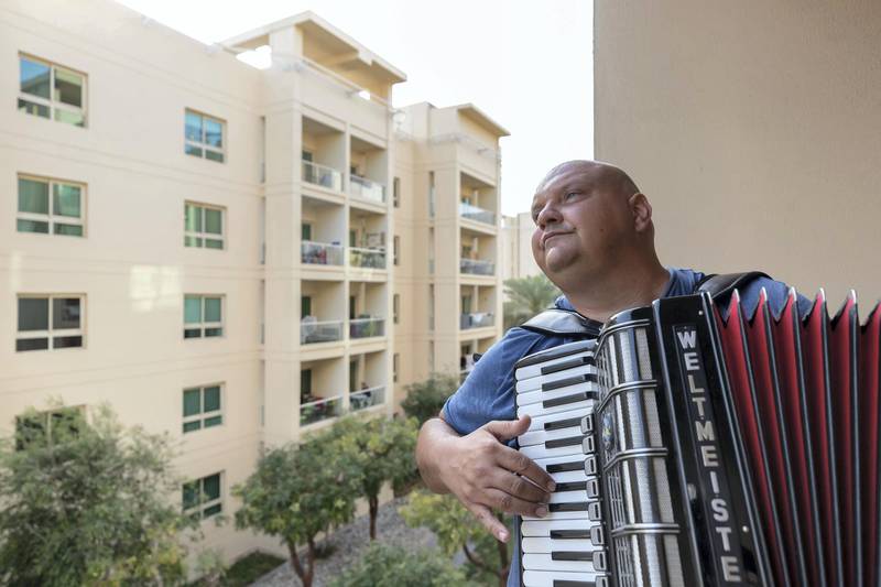 Dubai, United Arab Emirates - Reporter: Rory Reynolds: Boki Prekovic, a Serbian accordion player keeping residents stuck at home entertained from his balcony. Thursday, March 19th, 2020. The Greens, Dubai. Chris Whiteoak / The National