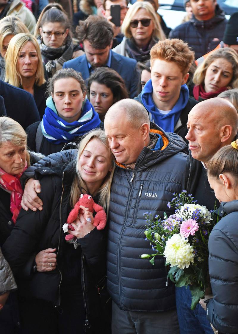 Leanne O'Brien, the girlfriend of Jack Merritt, is comforted by family members during a vigil at The Guildhall to honour him and Saskia Jones who were both killed in Friday's attack on London Bridge, in Cambridge, England, Monday, Dec. 2, 2019. London Bridge reopened to cars and pedestrians Monday, three days after a man previously convicted of terrorism offenses stabbed two people to death and injured three others before being shot dead by police. (Joe Giddens/PA via AP)